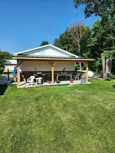 Covered patio addition with timber posts behind a home